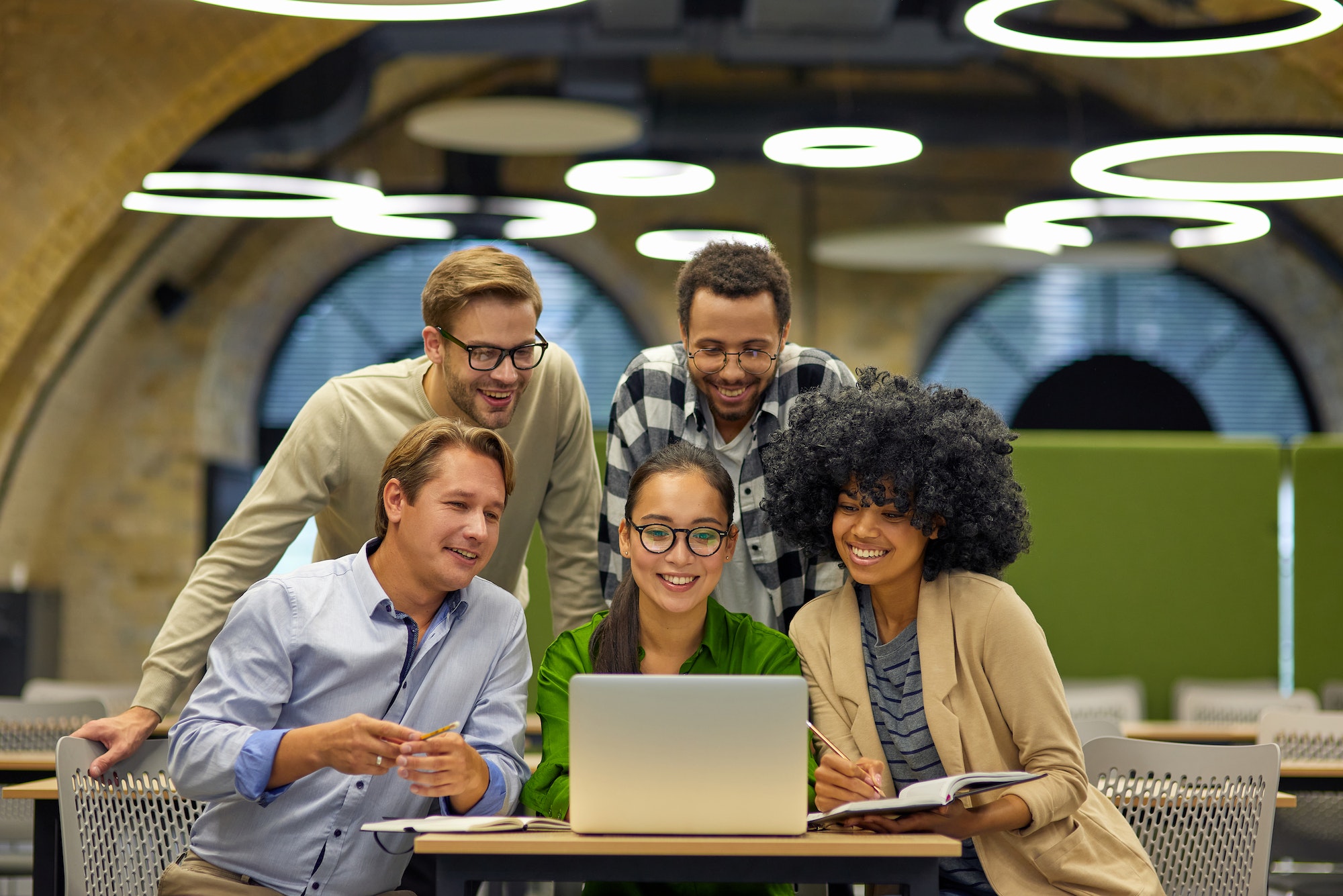 group-of-young-multiracial-business-people-sitting-at-desk-in-the-modern-coworking-space-looking-at.jpg